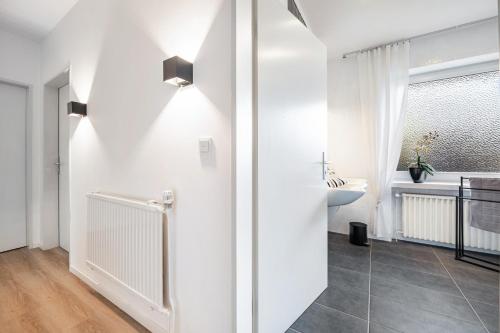 a white bathroom with a sink and a toilet at Ferienhaus Auszeit Meer in Cuxhaven