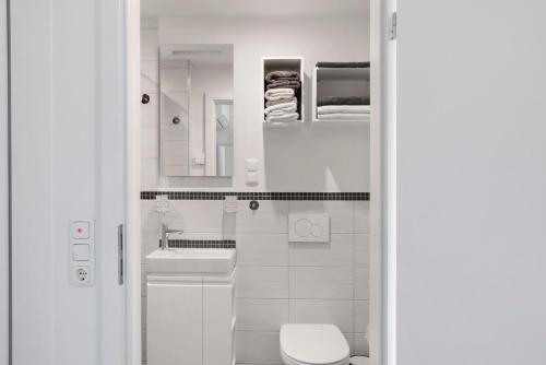 a white bathroom with a toilet and a sink at Ferienwohnung Eichenauer in Angersbach