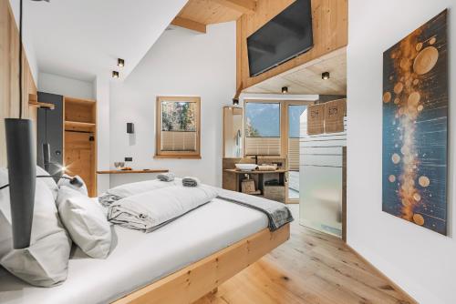 a bedroom with a large bed and a kitchen at See das Ferienhaus in Oetz