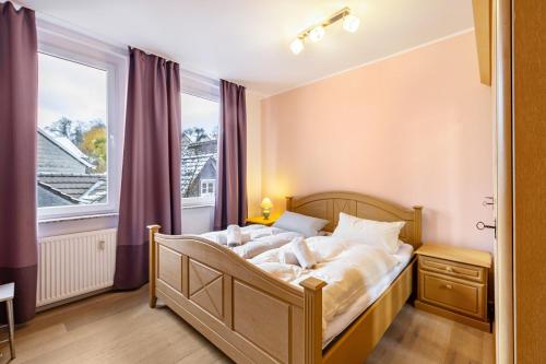 a bedroom with a bed and a large window at Serviced Apartments Xanthurus in Schwelm