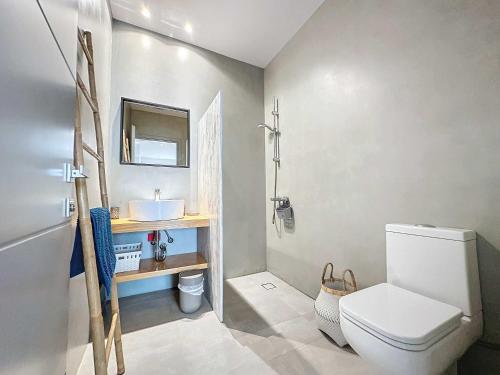 a bathroom with a white toilet and a sink at The Privacy Villa by Seaviews in Porto Heli