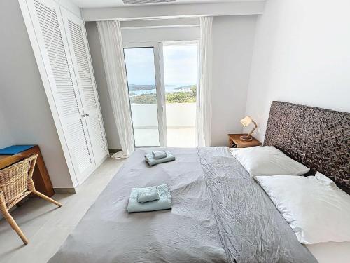 a bedroom with a large bed with two towels on it at The Privacy Villa by Seaviews in Porto Heli
