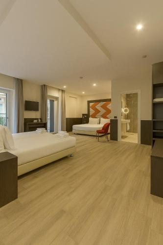a large bedroom with two beds and a desk at JR Hotels Bocconi Milano in Milan