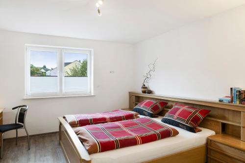 a bedroom with a bed and a window at Ferienwohnung Eichenauer in Angersbach