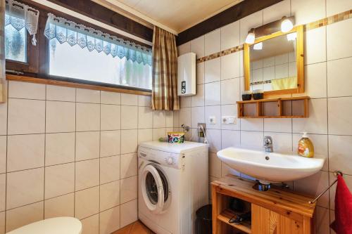 a bathroom with a washing machine and a sink at Ferienhaus Vorauf - Rosenbauer in Siegsdorf