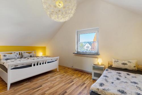 a bedroom with a bed and a window and a chandelier at Haus Kornfeld in Kehl am Rhein