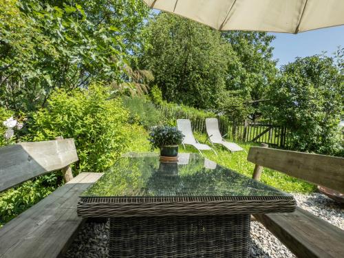 a glass table with a potted plant sitting on a wooden bench at Ferienhof Mrowka in Reutin