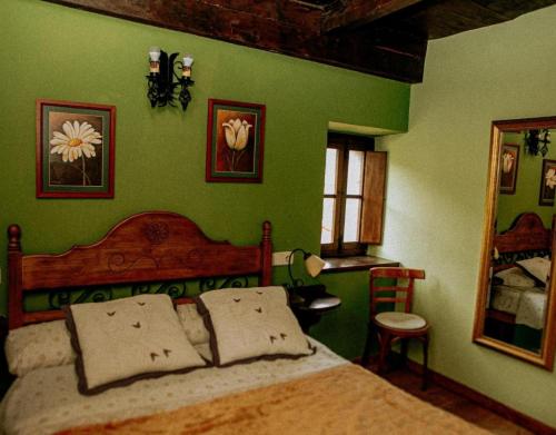 a bedroom with a bed and a green wall at El Jermoso in Posada de Valdeón