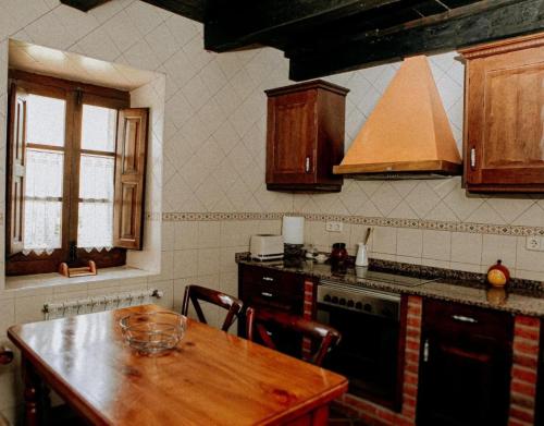 a kitchen with a wooden table and a stove at El Jermoso in Posada de Valdeón