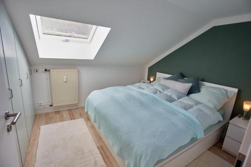 a bedroom with a large blue bed with a skylight at Angernest in Elfershausen