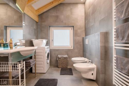 a bathroom with a sink toilet and a window at Cà Dei Nane Vermiglio in Vermiglio