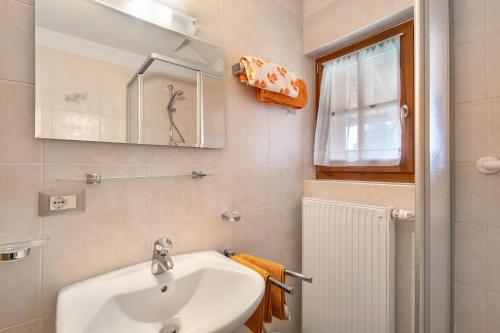 a bathroom with a sink and a mirror and a window at Inneroswalderhof in Anterselva di sotto
