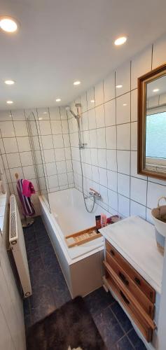 a bathroom with a tub and a sink at Ferienhaus am Wald in Reichshof 
