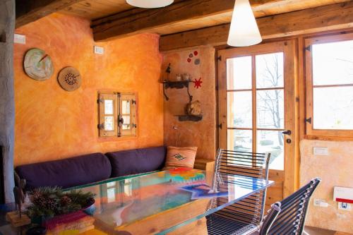 a living room with a blue couch and a glass table at Chalet Armonia Res Albert in San Guglielmo