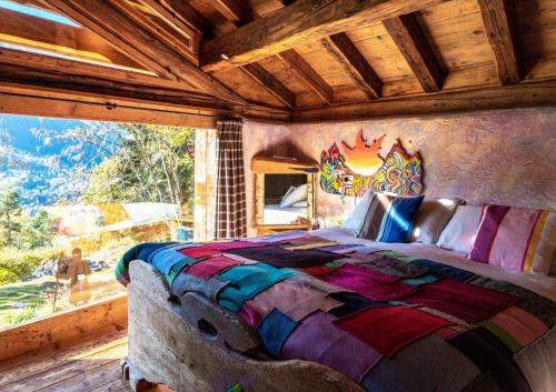 a bedroom with a large bed with a large window at Chalet Armonia Res Albert in San Guglielmo