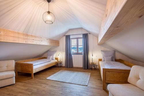 a attic room with two beds and a window at Ferienwohnung Josef in Gilching