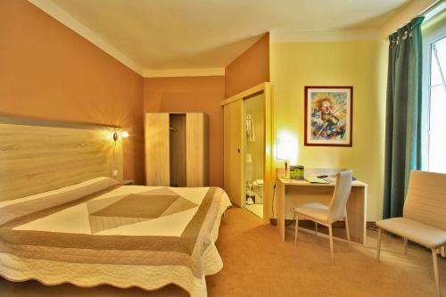 una camera d'albergo con letto e scrivania di Logis Hôtel Le Lion d'Or a Chauvigny