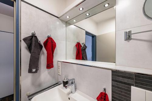 a bathroom with red socks and a mirror at Ferienwohnung Am Salzhaff B6 in Rerik