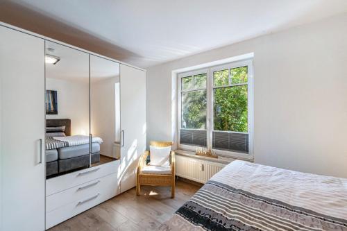 a bedroom with a bed and a window and a chair at Ferienwohnung Am Salzhaff B6 in Rerik