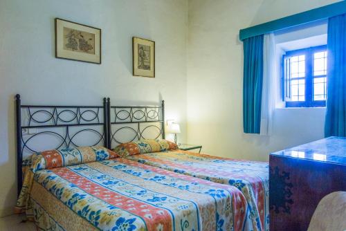 a bedroom with a bed with blue curtains and a window at Can Murenu in Sant Joan de Labritja