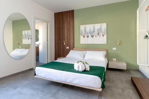 a bedroom with a bed with a green and white at Briamar Residence in Torre dell'Orso