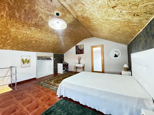a bedroom with a large white bed in a room at Refugio Senhora Paz in Marinhas