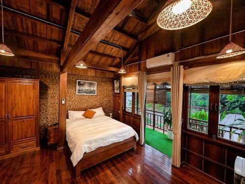 a bedroom with a bed in a room with wooden walls at Family Private Villa Hội An in Hoi An