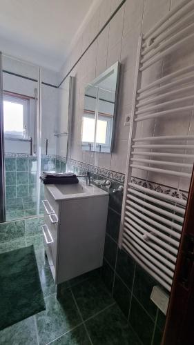 a bathroom with a sink and a mirror and a shower at Retiro do Viajante in Penacova