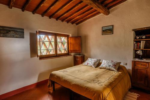 a bedroom with a bed and a window at Vallone di Cecione in Greve in Chianti
