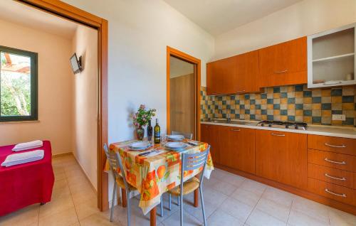 a kitchen with a table with chairs and a counter at Lilybeo Village - Camping & Residence in Marsala