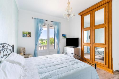 a bedroom with a bed and a window and a television at Casa Vacanze Le Giuggiole in Spongano