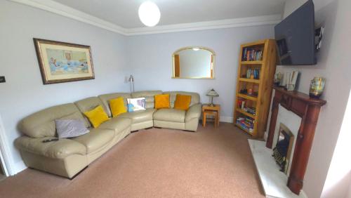 a living room with a couch and a book shelf at Bewick House Large three bedroom Sleeps upto six in Newbiggin-by-the-Sea