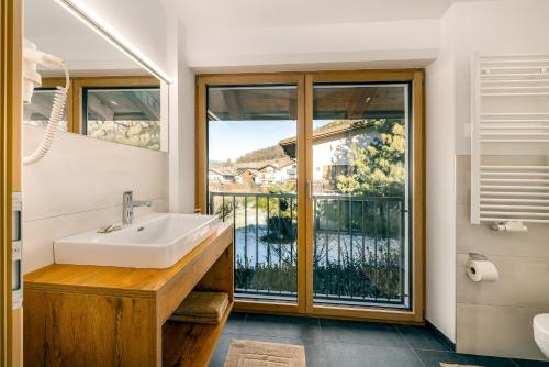 a bathroom with a sink and a large window at Untermoarhof Albeins in Bressanone