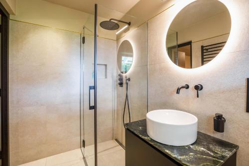 a bathroom with a sink and a shower at Kraidlhof Designapartment Isabel in Cortaccia