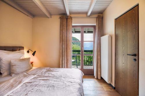 a bedroom with a bed and a large window at Kraidlhof Designapartment Isabel in Cortaccia