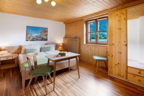 a room with a bed and a table and chairs at Bauernhof Sackgut in Ciardes