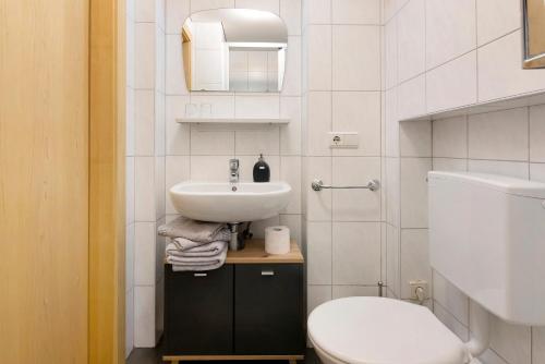 a white bathroom with a sink and a toilet at Bauernhof Sackgut in Ciardes