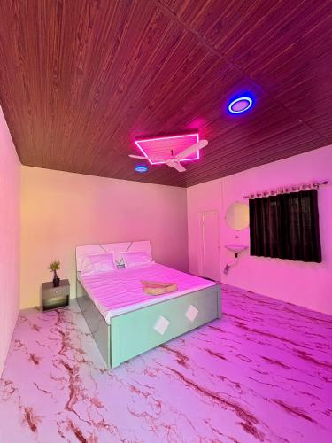 a pink bedroom with a bed and a purple ceiling at Gawkari Hillside Agroturism in Satara