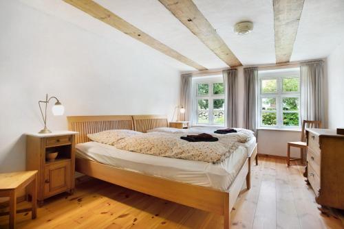 a bedroom with a bed and two windows at Pommernhuus an de Kark in Süderholz