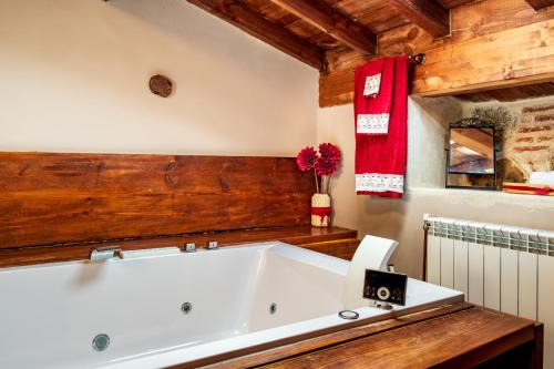 a large white bath tub in a room with wooden walls at La Cantina in Villar de Corneja