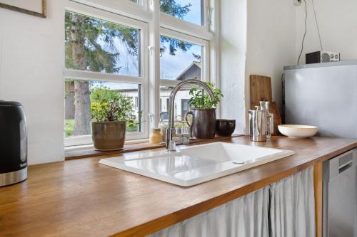 a kitchen counter with a sink and a window at Pommernhuus an de Kark in Süderholz