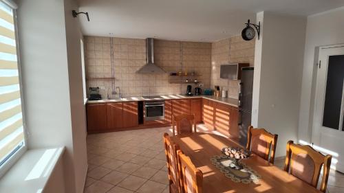 eine Küche mit einem Holztisch und Stühlen in einem Zimmer in der Unterkunft Bele House in Karmėlava