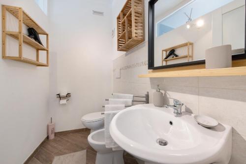 a white bathroom with a sink and a toilet at Il Gelsomino in Castro