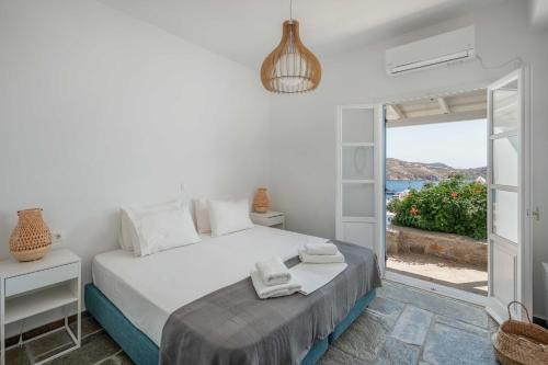 a bedroom with a bed and a view of the ocean at Bella Vista Vacation House in Serifos Chora