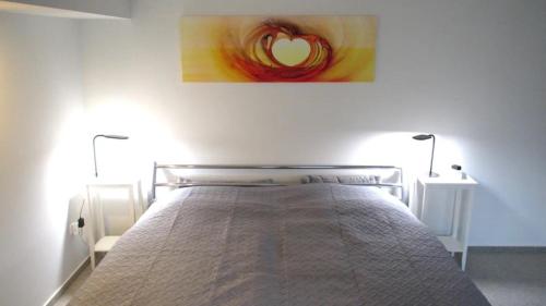 a bedroom with a bed with two lamps and a painting at Fewo Deister Bikertraum in Wennigser Mark