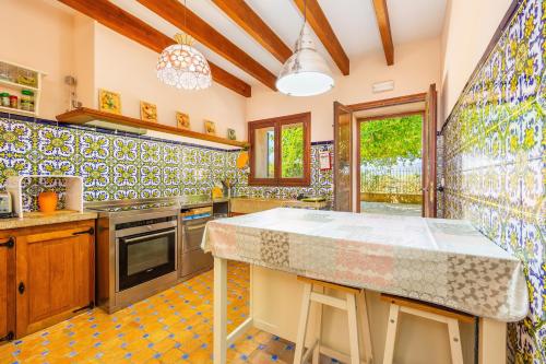 a kitchen with tiles on the walls and a counter at Es Pouet in Binissalem