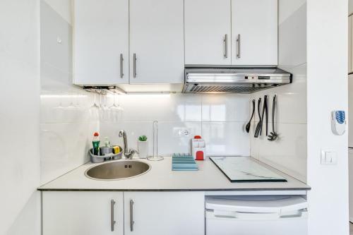 a kitchen with white cabinets and a sink at Ventana Loft in Empuriabrava