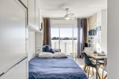 a bedroom with a bed and a desk and a table with chairs at Ventana Loft in Empuriabrava