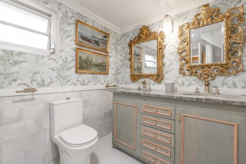 a bathroom with a toilet and a sink and mirrors at La Fabriqueta Studio in Ríudecañas