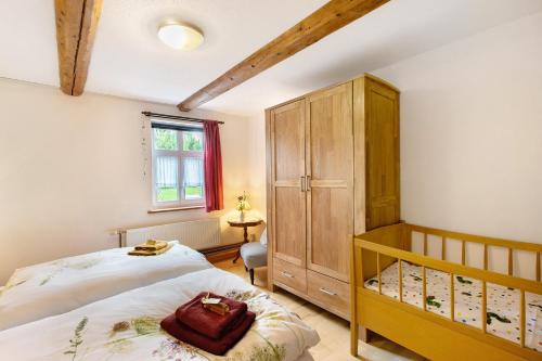 a bedroom with a bed and a wooden cabinet at Ferienwohnung Gute Stube in Veckenstedt